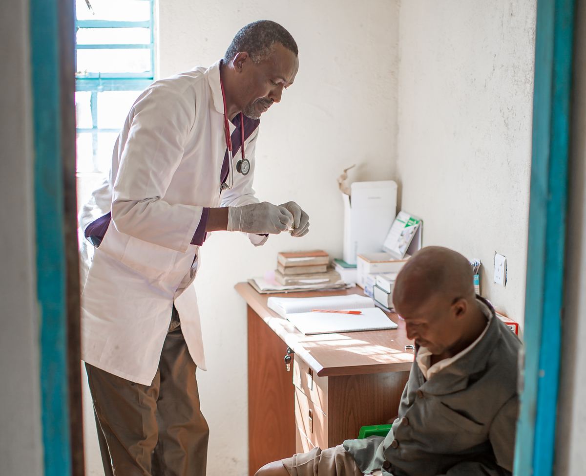 A doctor attending to a seated patient in the Empukani Medical Clinic's consulting room