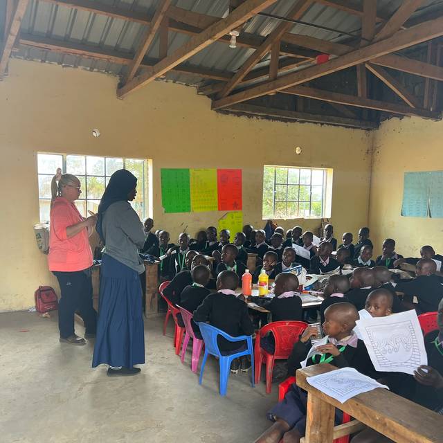 A full classroom at the school in Empukani, a teacher and a visitor at the front