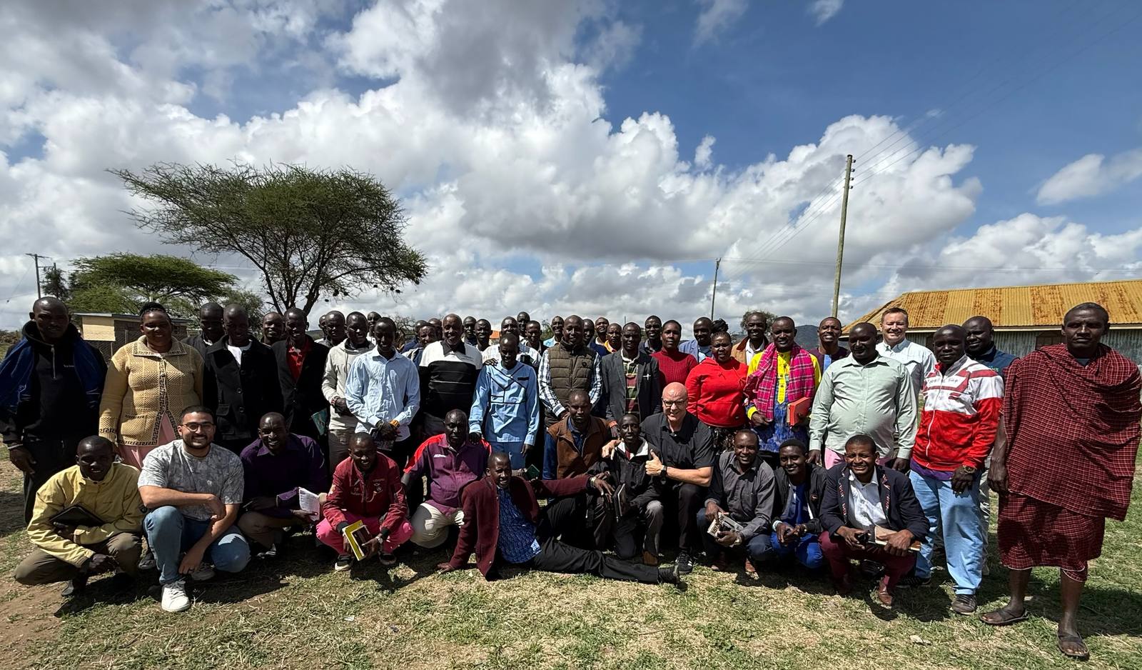 The pastors of the network gathered outside at Empukani under an acacia tree, Bibles and notebooks in hand, some in shukas and some in jackets